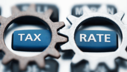 Federal tax rates-tycoonstory | tycoonstory media Tax liabilities: close-up of two gears with the words'TAX' and 'RATE' on blue buttons, representing the factors involved in determining tax liabilities.