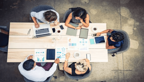 Networking and collaboration A group of professionals collaborating around a table, discussing business strategies and sharing data, exemplifying the power of networking and collaboration.