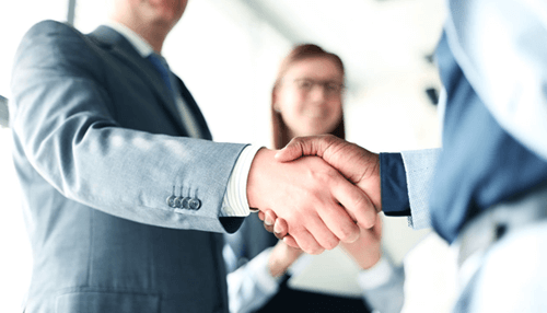 Check the levels of professionalism - tycoonstory | tycoonstory media Business professionals shaking hands, representing successful collaboration or hiring of a software developer