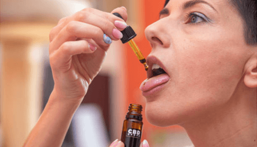 Get from cbd oil strains - tycoonstory | tycoonstory media Woman placing cbd oil drops under her tongue using a dropper bottle, demonstrating sublingual use of cbd oil strains.