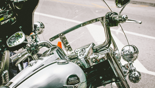 How does harley davidson look Close-up view of a harley motorcycle’s chrome handlebars and logo, capturing the classic design and powerful style of harley bikes.