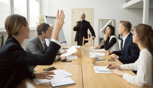 Keep your manager in the loop-tycoonstory | tycoonstory media Micromanagement concept showing a magnifying glass closely inspecting a single wooden figure among a group.