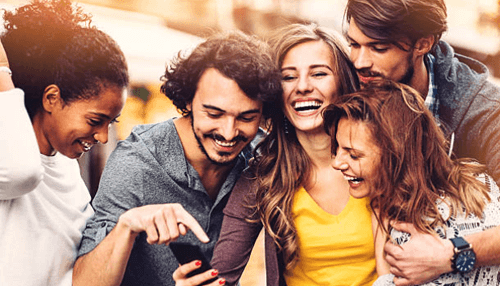 Public on stock exchange - tycoonstory | tycoonstory media Group of young adults smiling while checking a smartphone, symbolizing everyday investors engaging with public company shares through mobile platforms.