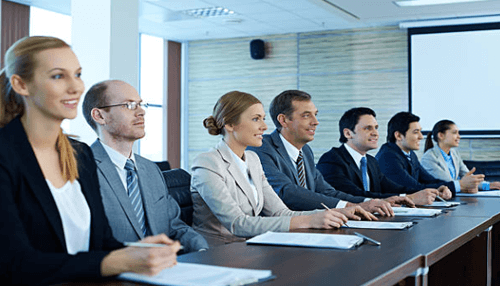 Who can become a shareholder Shareholder board meeting featuring corporate leaders seated at a conference table, representing governance, voting rights, and company oversight.