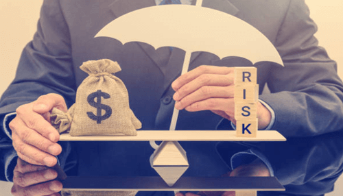 Financial risk-tycoonstory | tycoonstory media A businessman balancing a money bag and a risk block under an umbrella, symbolizing the importance of managing financial risk when investing seed capital in startups.