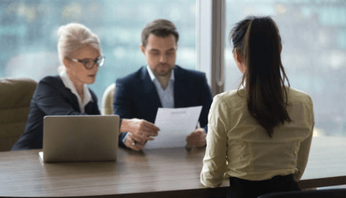 Hiring process-tycoonstory | tycoonstory media Two hiring managers reviewing a candidate’s resume during an interview, illustrating recruitment and selection processes in hr management.