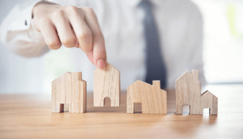 Choose the right bank for business
A hand placing a wooden house model on top of others, representing the steps and fundamentals involved in building a business from the ground up.