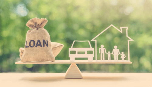 Loan Wooden scale balancing a loan bag and symbols of a family and home, representing commercial real estate financing.