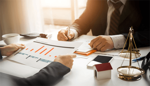 How an accountancy firm can benefit your business finances-tycoonstory | tycoonstory media Two professionals discussing financial reports and strategies at a desk, with an accounting firm helping with decision-making and planning.