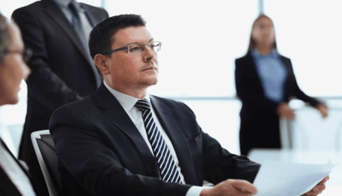 Role of shareholders-tycoonstory | tycoonstory media Business professional reviewing documents during a corporate meeting with other executives.