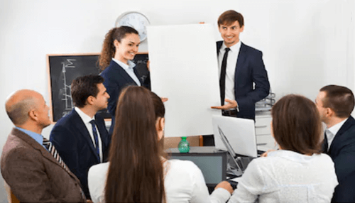 Startup incubators make money A business team presenting a project in a meeting, showcasing how startup incubators make money through investment and business development.