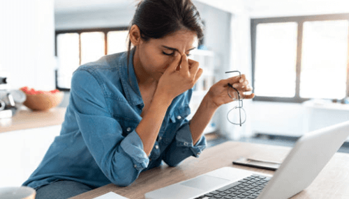 Work pressure-tycoonstory | tycoonstory media Employee stressed at her desk, showing the impact of inefficiency at the workplace