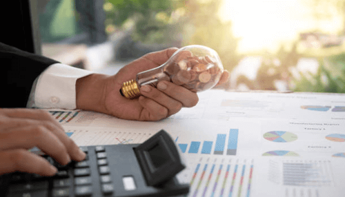 Financial savings A business professional holding a lightbulb filled with coins, symbolizing the cost savings and financial benefits of solar power.