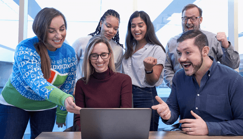 Creating leaders for tomorrow - tycoonstory | tycoonstory media Team celebrating success around a laptop, showcasing employee recognition through praise, teamwork, and appreciation for outstanding performance.
