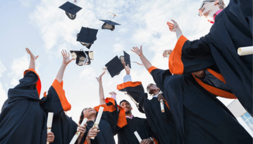 Masters of science in business analytics Happy mba graduates celebrating by tossing their graduation caps into the air.