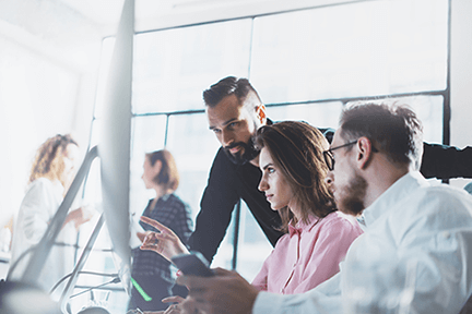Office team Professional team collaborating in a modern office, discussing ideas and strategies around a computer screen.