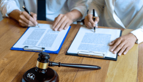 Important factor is when you get divorced Two individuals signing legal documents with a gavel in the foreground, symbolizing the legal process and divorce proceedings for a foreign national.