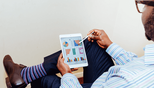 Saas keyword research strategy A professional analyzing colorful charts and graphs on a tablet to evaluate business performance and growth metrics for saas companies.