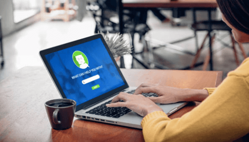 Muti-lingual chatbot A woman typing on a laptop with a customer support bot interface on the screen, showcasing a muti-lingual chatbot in action.