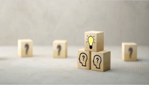 Top advice for startup founders Wooden blocks showing question marks and a lightbulb, symbolizing the creative problem-solving of startup founders.