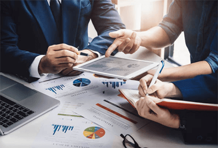 Conduct market research-tycoonstory | tycoonstory media Business team analyzing marketing charts and digital data to improve brand performance and strategy.