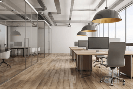 Proper planning of office interior design-tycoonstory | tycoonstory media Modern workplace with wooden floors, glass partitions, pendant lights and desks with computers, and ergonomic chairs.