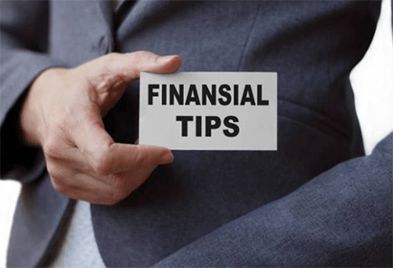 Financial freedom tips Person holding a card labeled ‘financial tips’ while wearing a business suit.