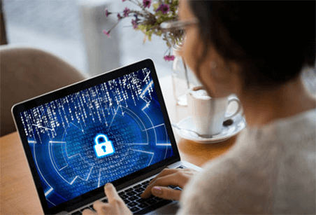 Business data protection-tycoonstory | tycoonstory media A woman working on a laptop displaying a digital security lock icon, symbolizing online privacy and cybersecurity protection.