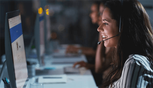 Offering in marketing Customer support representative smiling while assisting clients at a computer, representing service-based offering in marketing.