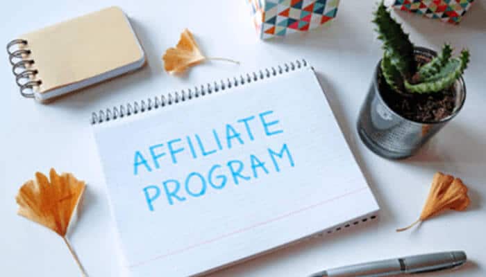 Affiliate programs | tycoonstory media Notebook with the words affiliate program surrounded by office supplies, illustrating partnership and referral opportunities with taxconnex