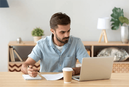 Professional analyzing data and managing accounts using Telecom Billing Software on a laptop at home workspace.