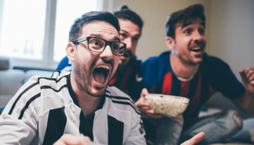 Find out before betting - tycoonstory (1) | tycoonstory media Group of excited friends cheering while watching a game and reacting to sports bets results on tv.