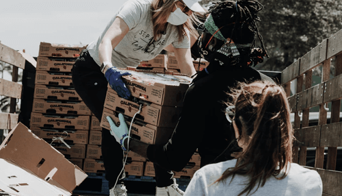 Securing packages Warehouse workers lifting and organizing boxes while securing packages for shipment and distribution