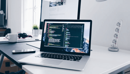 Tech stack Developer writing code on a laptop showcasing the software development tech stack in use.