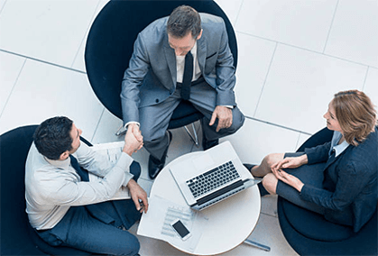 Thrive as an entrepreneur A business meeting between three professionals, shaking hands to seal a deal, demonstrating collaboration and networking essential to thrive as an entrepreneur.