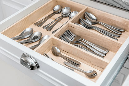 Manufacturing flatware-tycoonstory | tycoonstory media A neatly organized kitchen drawer with assorted flatware, including spoons, forks, and knives, arranged in wooden dividers for easy access.