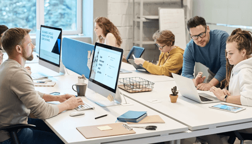 Employees Professionals working at computers in a shared office environment, designing strategies and managing workflows for business gifts.