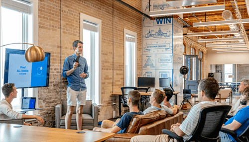 A trustworthy brand image - tycoonstory | tycoonstory media Team meeting in a modern office with a presentation in progress, highlighting collaboration and building a positive brand image.