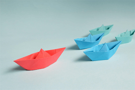 Develop leadership skills-tycoonstory | tycoonstory media A red paper boat leading blue boats, symbolizing leadership, direction, and the path toward achieving the highest paying career.