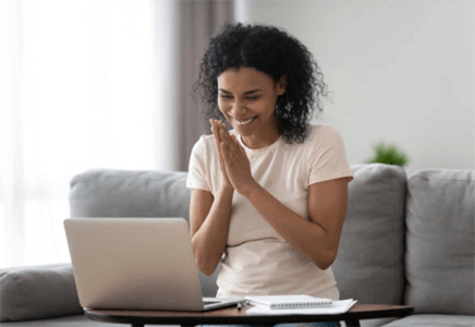 Grant opportunities-tycoonstory | tycoonstory media Smiling woman celebrating success on a laptop, representing the achievements of veteran-owned businesses.