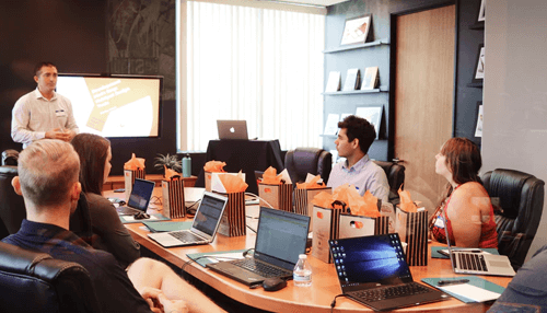 Transformational leadership Business leader conducting a strategy meeting with professionals, highlighting transformational leadership focused on motivation, vision, and organizational growth.