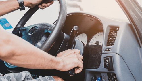 Car key won't Turn Driver attempting to turn the ignition key inside a car, highlighting a situation where the car key won't Turn due to steering lock or ignition problems.