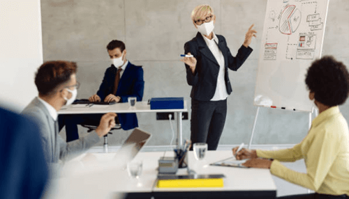 Startup productivity Business team in a meeting with a presenter explaining charts on a whiteboard, demonstrating planning and startup productivity.