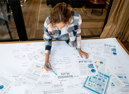 Home-based entrepreneur Home-based entrepreneur reviewing business strategy charts and financial plans at a workspace, highlighting startup planning, analytics, and growth management from home-based entrepreneur.