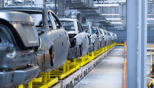 Car industry Row of unfinished vehicle frames on a production line inside an automotive manufacturing plant, showcasing advanced processes in the car industry.