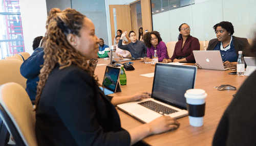 Many potential customers: social media for businesses Business team in a conference room discussing digital strategies with laptops and tablets, focusing on social media for businesses.