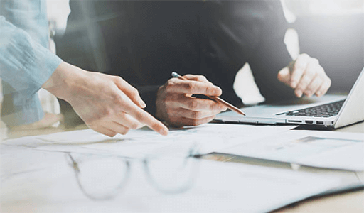 Steps to follow to derive a successful business road map-tycoonstory | tycoonstory media Team reviewing documents and discussing strategies on a laptop to plan road map and achieve businesssuccess.