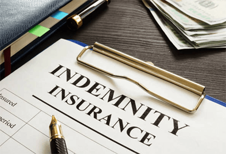 What is the concept of a no search indemnity insurance-tycoonstory | tycoonstory media A close-up of a clipboard with indemnity insurance paperwork, money, and keys on a wooden desk, illustrating financial coverage and liability protection.