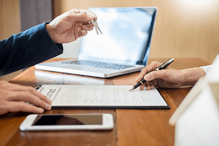 Home buying process-tycoonstory | tycoonstory media A home buyer signing the home purchase contract as keys are handed over symbolizing home buying with dollarback mortgage.