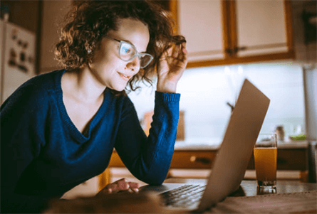 Make money from twitter Woman working on a laptop at home, researching online opportunities and content creation methods to make money from twitter through digital engagement and monetization.